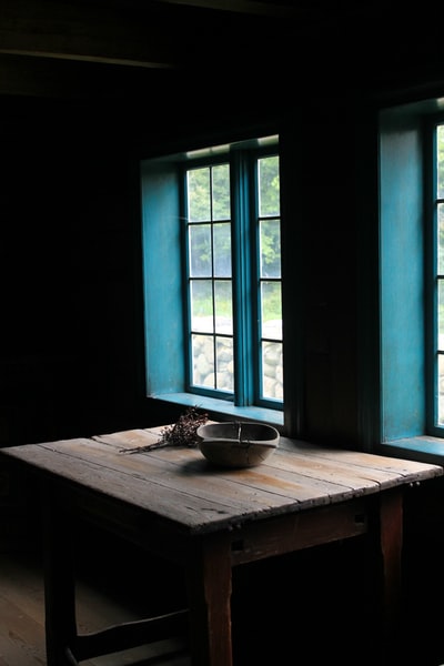蓝色窗格旁的棕色方形木制餐桌